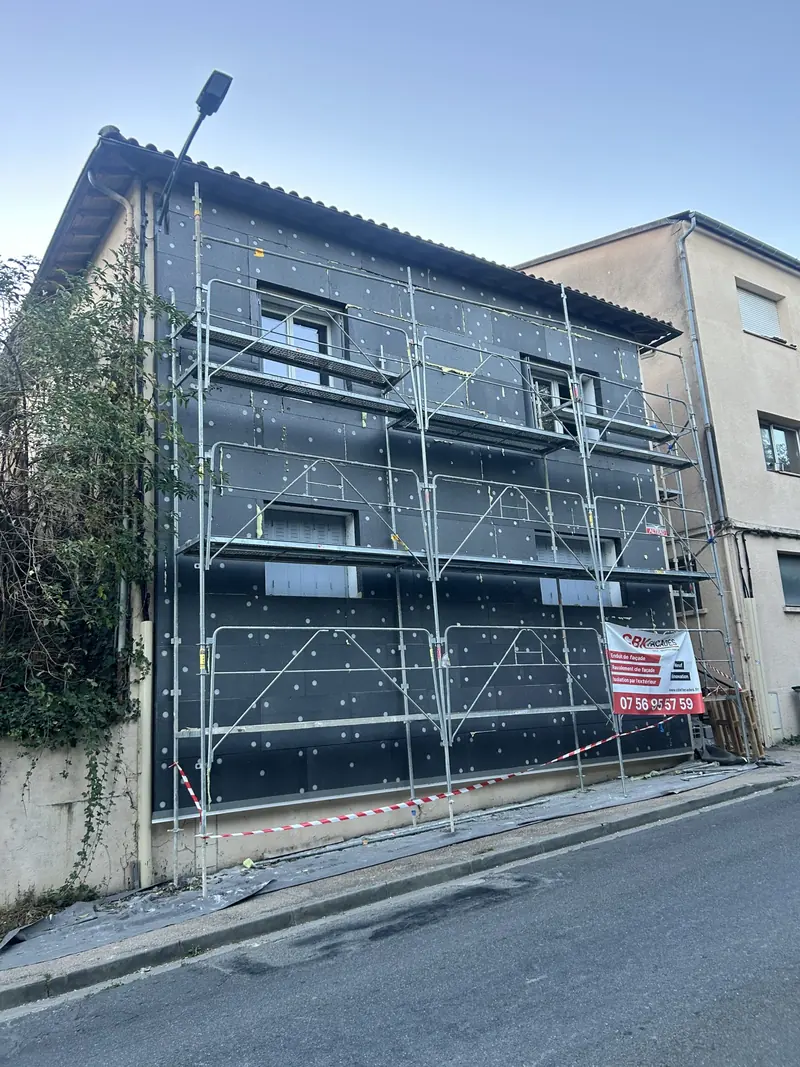 Façade en travaux sous échafaudage bâché, en agglomération toulousaine